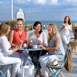 Freundinnen trinken Kaffee und Eis auf der Promenade