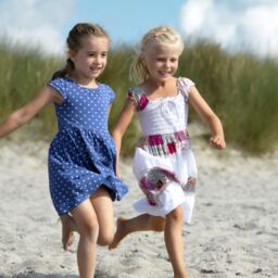 Kinder spielen fröhlich am Strand im Sommerurlaub
